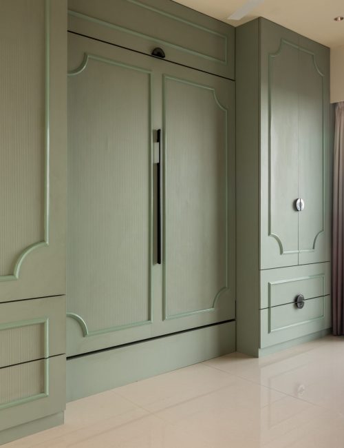 Spacious wardrobe in muted green with black handles